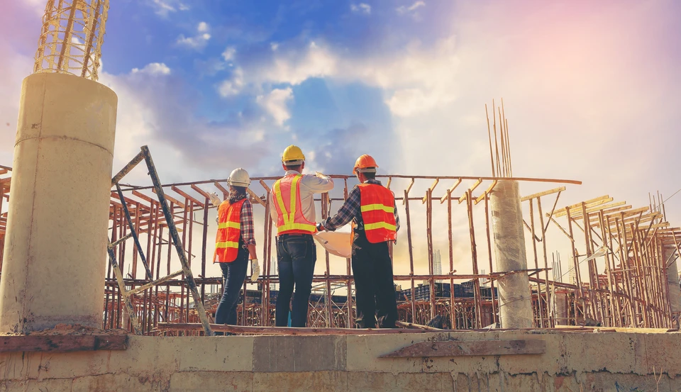 Ingénieur de structure et architecte et contremaître travailleur avec des plans discutent, abonnement travaillant pour le chantier de construction en plein air