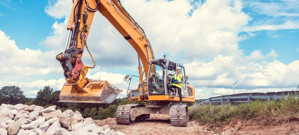 Chantier de construction en extérieur avec pelleteuse hydraulique orange en action