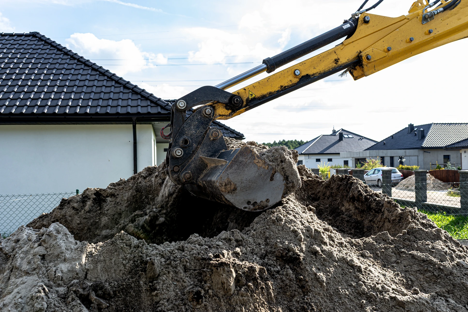 Chantier de construction extérieur avec pelleteuse hydraulique jaune en activité sur terrain de terrassement